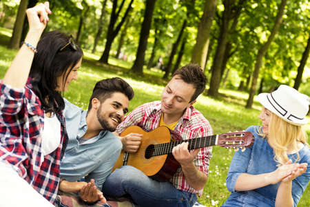 A sunny scenery of a group of young friend having fun in a parkの写真素材