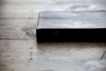 A close shot of a holy bible on a wooden surface