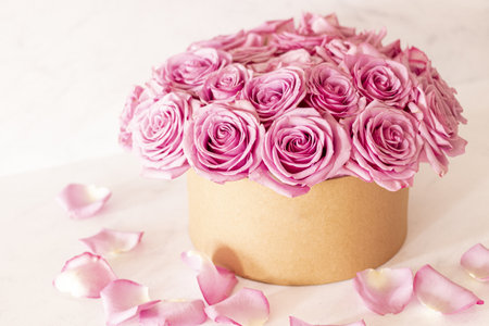 A beautiful floral bouquet with pink roses in a box on a pink background