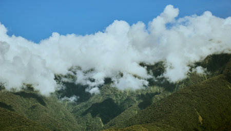 A panoramic view of a mountain with a cloudy day background