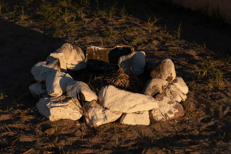 A high angle shot of stones in a circle for a bonfire at the beach