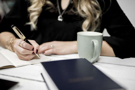 A selective closeup shot of a person taking notes off of a bookの写真素材