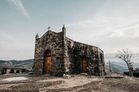 A horizontal shot of an old small church on a mountainの写真素材