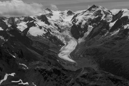 A beautiful grayscale shot of snowy rocky mountainsの写真素材