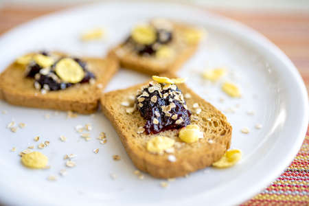 A closeup shot of toasted bread with blueberry jam, oats, and corn flakesの写真素材