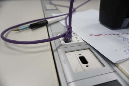A closeup of a purple cable plugged into a socket