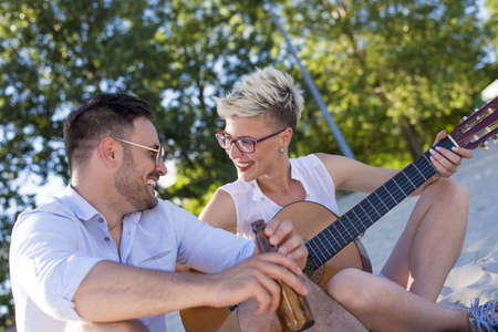 A shallow focus shot of a young Caucasian couple having fun on the beach