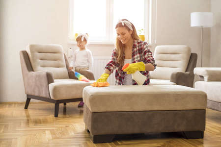 A daughter and mother cleaning home together and having funの写真素材