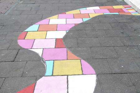 A curvy section of bricks painted with various light colors