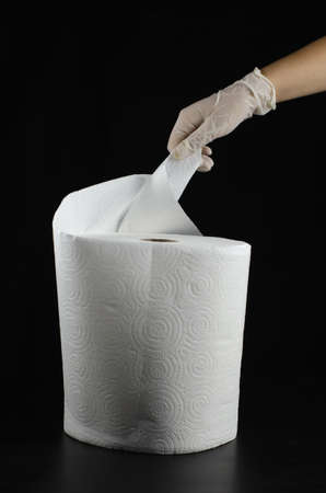 A vertical shot of a person with gloves holding a tissue isolated on a black backgroundの写真素材