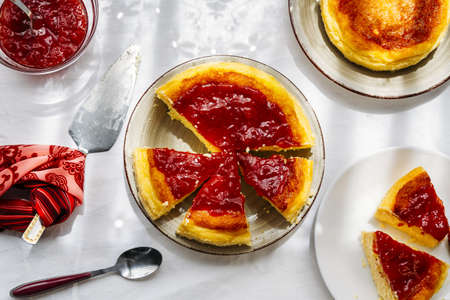 A high angle shot of delicious homemade pies covered with fresh jam on a white surface
