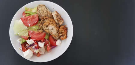 Grilled chicken breast meat with Greek salad.