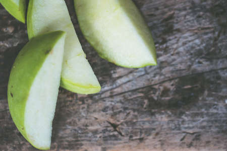 A closeup shot of sliced apples on a wooden backgroundの写真素材
