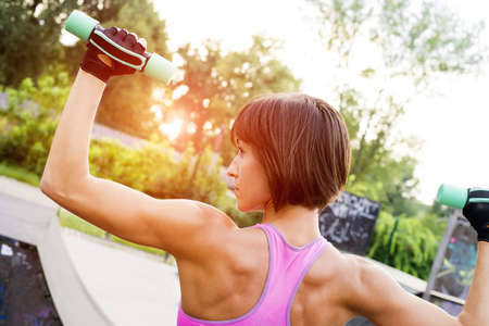 A shallow focus shot of a sporty Caucasian female doing workout in the park