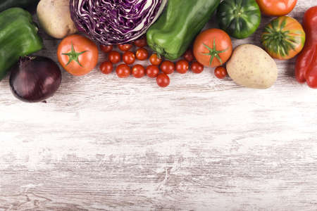 A high angle shot of fresh vegetables on a wooden surface - with empty space for text