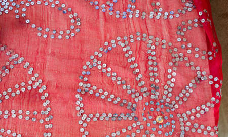 A closeup shot of designs on a light red fabric - perfect for background