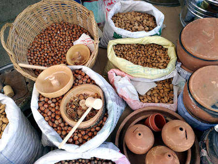 An overhead shot of hazelnuts and almonds in bags