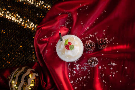 An overhead shot of a smoothie with a cherry on top on a red blanketの写真素材