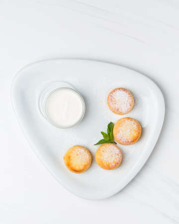 A vertical shot of baked pastry with sugar powder on a white plate