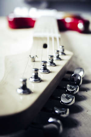 A selective closeup shot of a tailpiece of a white and red electric guitar