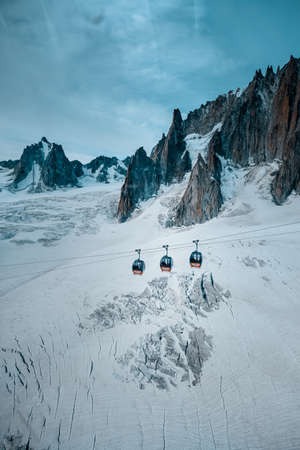 A vertical shot of cable ropeways near ruth glaciers covered in snowの写真素材