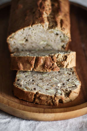 A vertical selective closeup shot of sliced brown bread with rice on a wooden oval tray