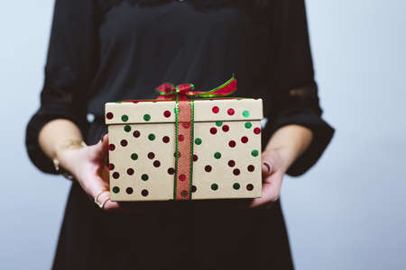 A selective closeup shot of a person holding a decorated gift boxの写真素材