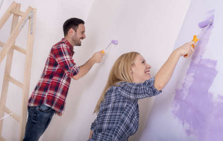 A picture of a beautiful couple repairing their houseの写真素材