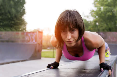 A shallow focus shot of a sporty female doing a workout in the park