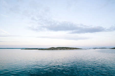 A beautiful shot of a sea with a mountain in the background under a beautiful skyの写真素材