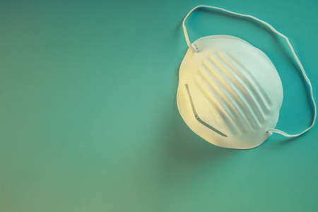 A high angle shot of a sanitary mask isolated on a blue surface - Pandemic