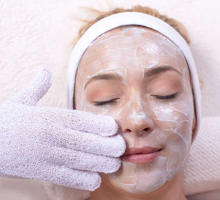 A top view of a beautiful young Caucasian female applying face skin maskの写真素材