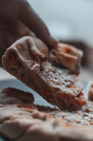 A vertical shot of an apple pie with cinnamon on a blue plateの写真素材