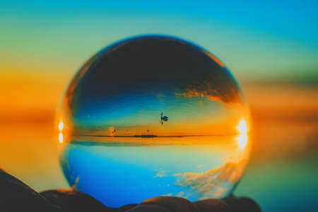 A beautiful creative lens ball photography of a swimming crane in the seaの写真素材