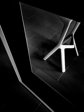 A vertical greyscale shot of a table with a black frame in a cafe during daytimeの写真素材