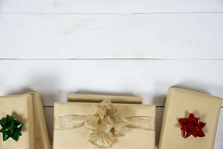 An overhead shot of presents on a white wooden surface great for writing a holiday text or a backgroundの写真素材