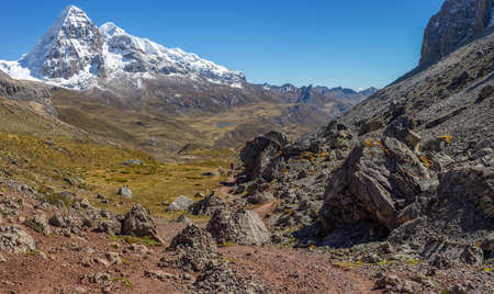 A landscape shot of a beautiful valley surrounded by huge mountains with snowy peaks. Perfect for a wallpaper or a background.の写真素材
