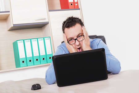 A young entrepreneur with his mouth open in shock at his business results