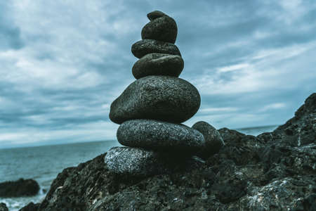 A closeup shot of perfectly balanced different sized rocks at the coast of the sea - perfect for stability depiction articlesの写真素材