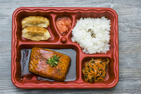 A high angle shot of a plate of seafood and rice on a wooden surface