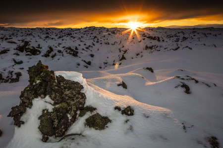 A breathtaking sunset over a snowy field in Lava Field, Icelandの写真素材