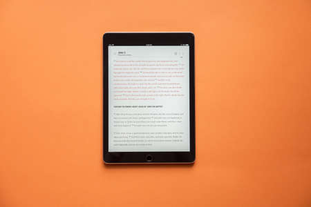 An overhead shot of a tablet on an orange surfaceの写真素材