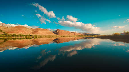 A breathtaking view of the reflection of the mountains and the beautiful blue sky in the riverの写真素材