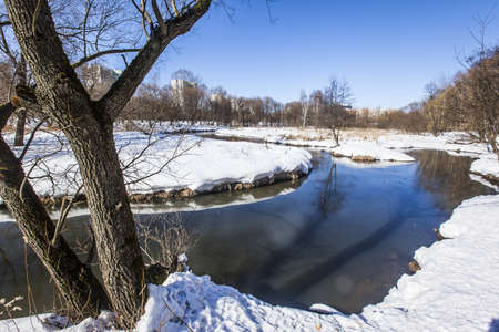 A landscape shot of the Yauza River in Moscow, Russia, during winter with the ground covered in snowの写真素材