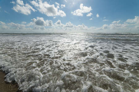 A beautiful shot of the foamy ocean under the bright calm sky - perfect shot for a desktop wallpaperの写真素材