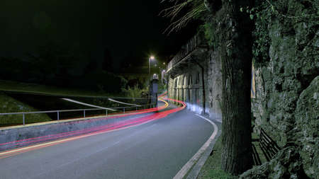 A horizontal timelapse shot of an empty road between the cliffs and the Como Lake in Italy