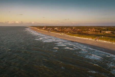 A high angle shot of the beach and the ocean under the clear sky in Domburg, Netherlandsの写真素材