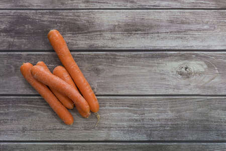 A closeup shot of fresh carrots on a wooden table