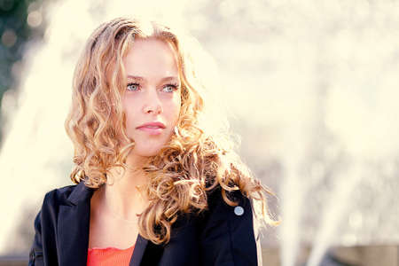 A shallow focus shot of a curly blonde model with hazel eyes with a thoughtful facial expressionの写真素材