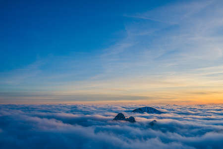 The breathtaking view of the beautiful clouds above the mountain peaks in the sky